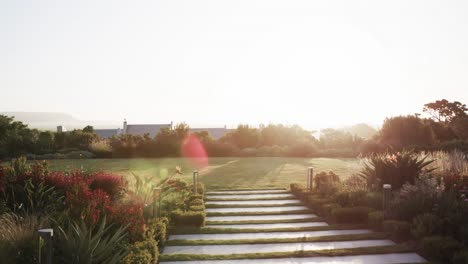 lawn with steps in big garden, trees and distant houses on sunny day in countryside, slow motion