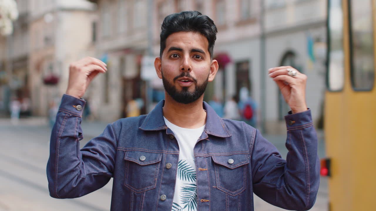 Young man looking surprised at camera shocked by sudden win good victory news wow in city street