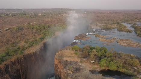 aerial orbits victoria falls revealing whitewater mist in gorge below