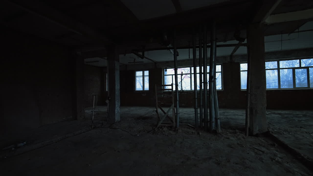Dark empty unfinished room in the industrial building. Warehouse under construction or demolition interior.