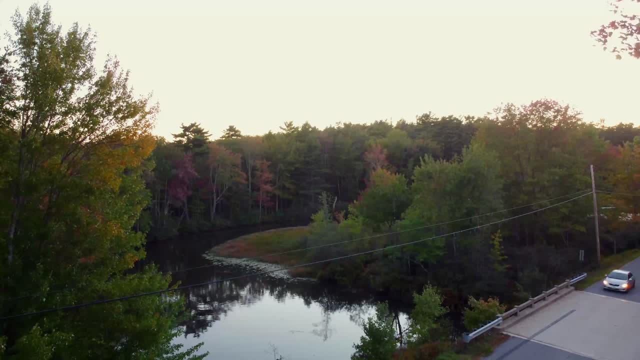 una toma panorámica desde la carretera con un sedán dorado pasando