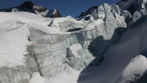 Aerial-view-of-a-glacier-with-relief,-snow-covered-ice-and-crevasses,-winter-landscape