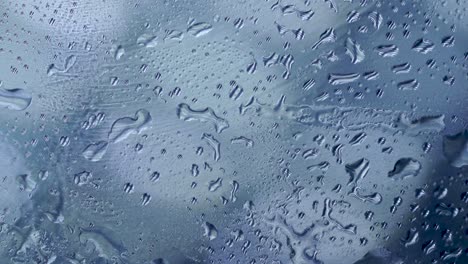 close-up of water droplets on glass, rain background with water drops on glass, after hard raining day. blue  light background, sadness lonely blue mood, isolated solitude, emotional, science concept