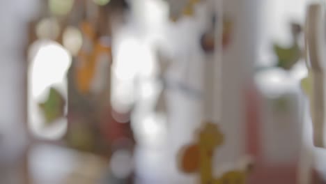 close-up of colorful animal-shaped baby mobile, softly swaying indoors with soft focus