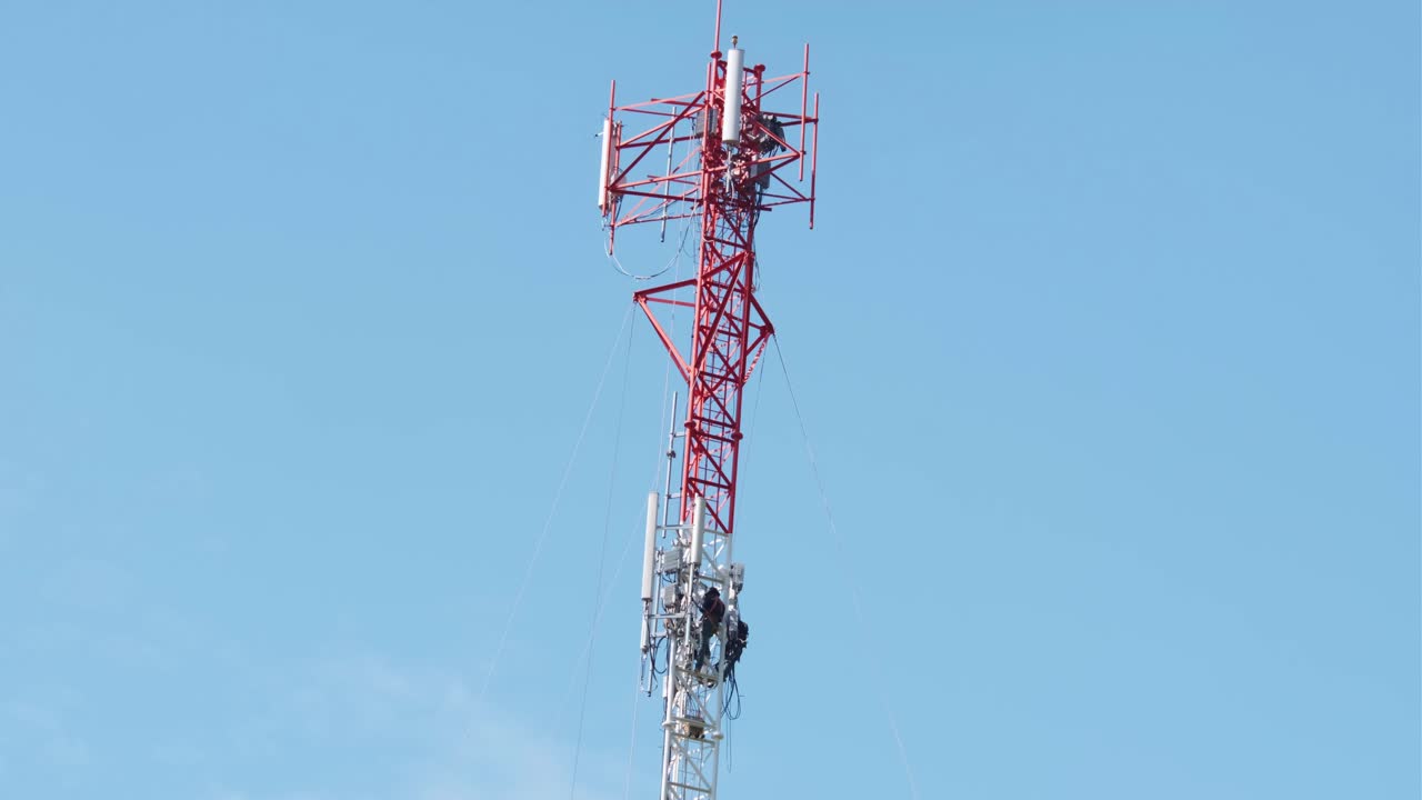 hombre trabajando en una torre de comunicación y realizando reparaciones o mantenimiento