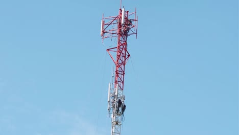 hombre trabajando en una torre de comunicación y realizando reparaciones o mantenimiento
