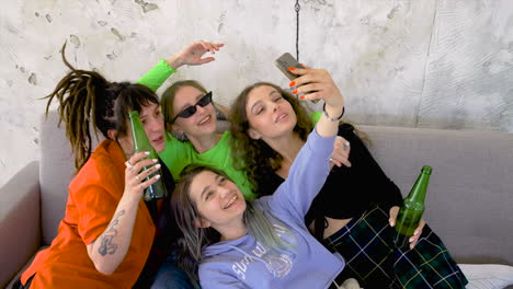 four girls having good time and taking pictures of themselves with a smartphone