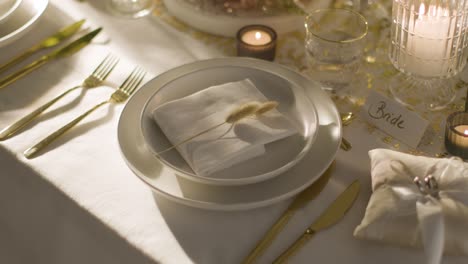 table set for meal at wedding reception with place card for bride and rings