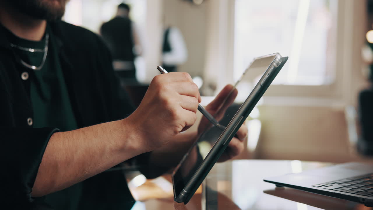 Primo piano di un uomo che usa un tablet digitale con uno stilo per lavoro creativo