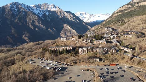 Aerial-drone-view-of-a-resort-town-located-at-the-foot-of-the-pyrenees-in-a-sunny-day
