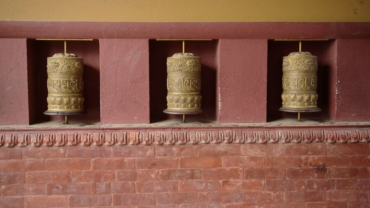 Kathmandu Tibetan Buddhist Prayer Wheels in Nepal at Boudhanath Stupa, Religious Symbol of Buddhism used for Praying Decorated with Gold Leaf at a Popular Buddhist Religious Temple Site