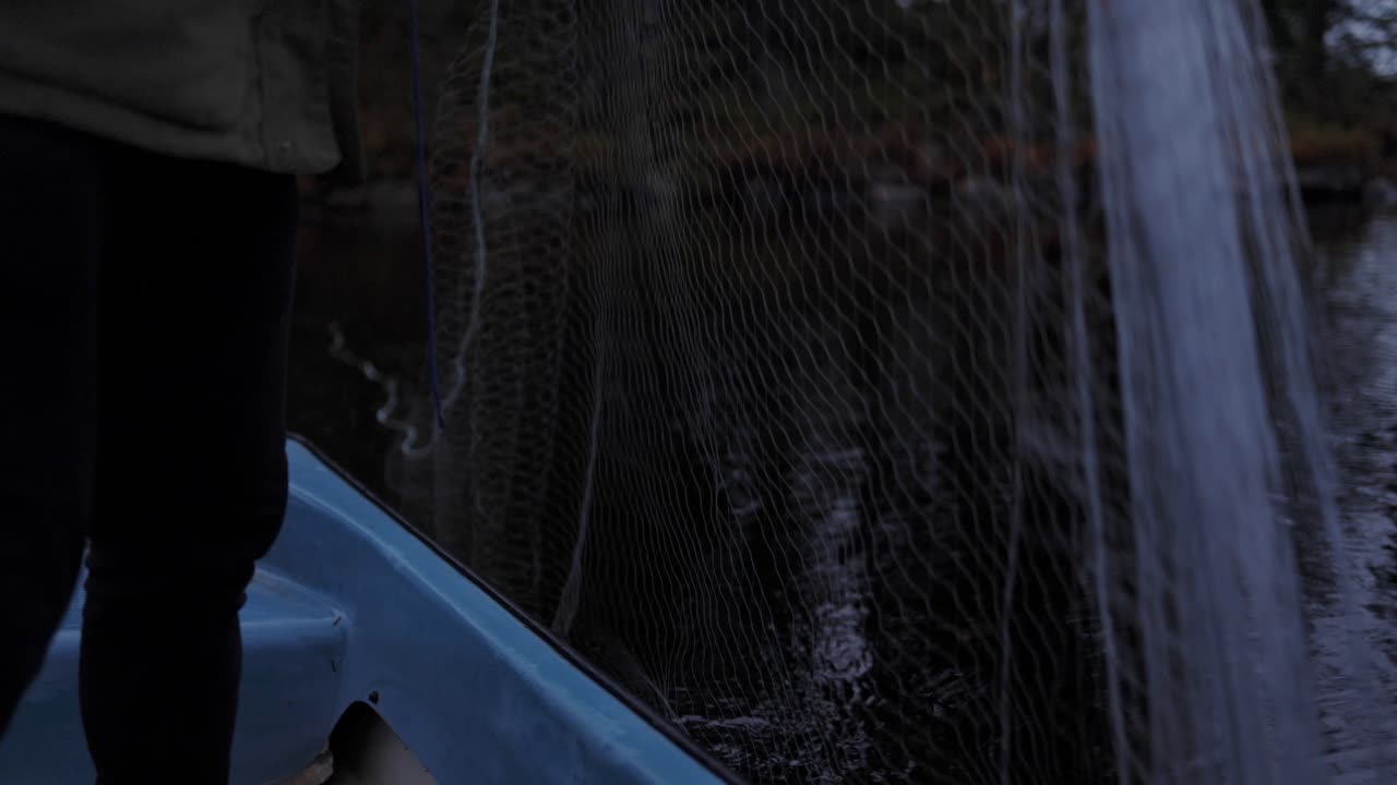 Primo piano: l'uomo che aspetta di pescare un pesce con la sua rete nel tranquillo fiume della Norvegia