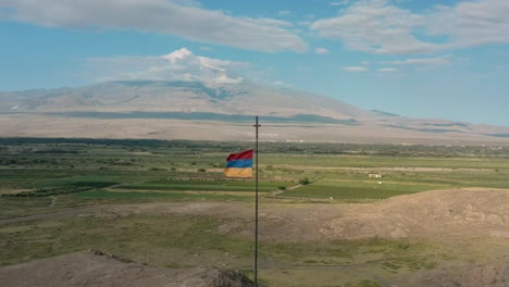 aerial drone shot pan shot of flag waving on the hill in armenia