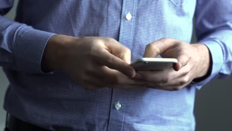 man using smart phone, holding and typing on cell phone in hands