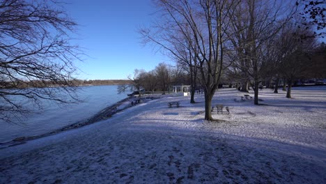 Niagara-On-the-Lake-Beach-during-Winter-with-white-snow-everywhere-with-people-walking-at-a-distance-during-bright-day-with-blue-sky---Ontario,-Canada-tourist-location