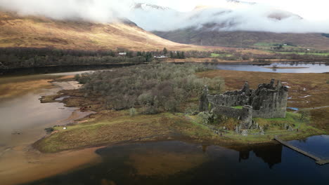 Downward-Arc-Aerial-View-of-a-Derelict-Castle-in-Middle-of-Lock-Awe