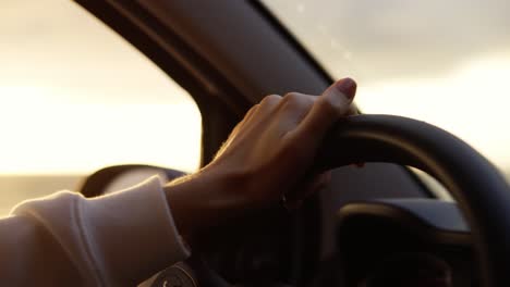 Close-up-footage-of-a-woman-with-nude-manicure-driving-a-car-along-the-coast