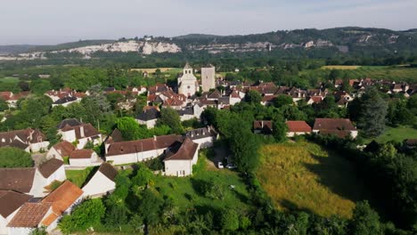 Circular-aerial-view-of-the-village-of-Floirac,-with-cliffs-behind-the-church,-Lot,-France