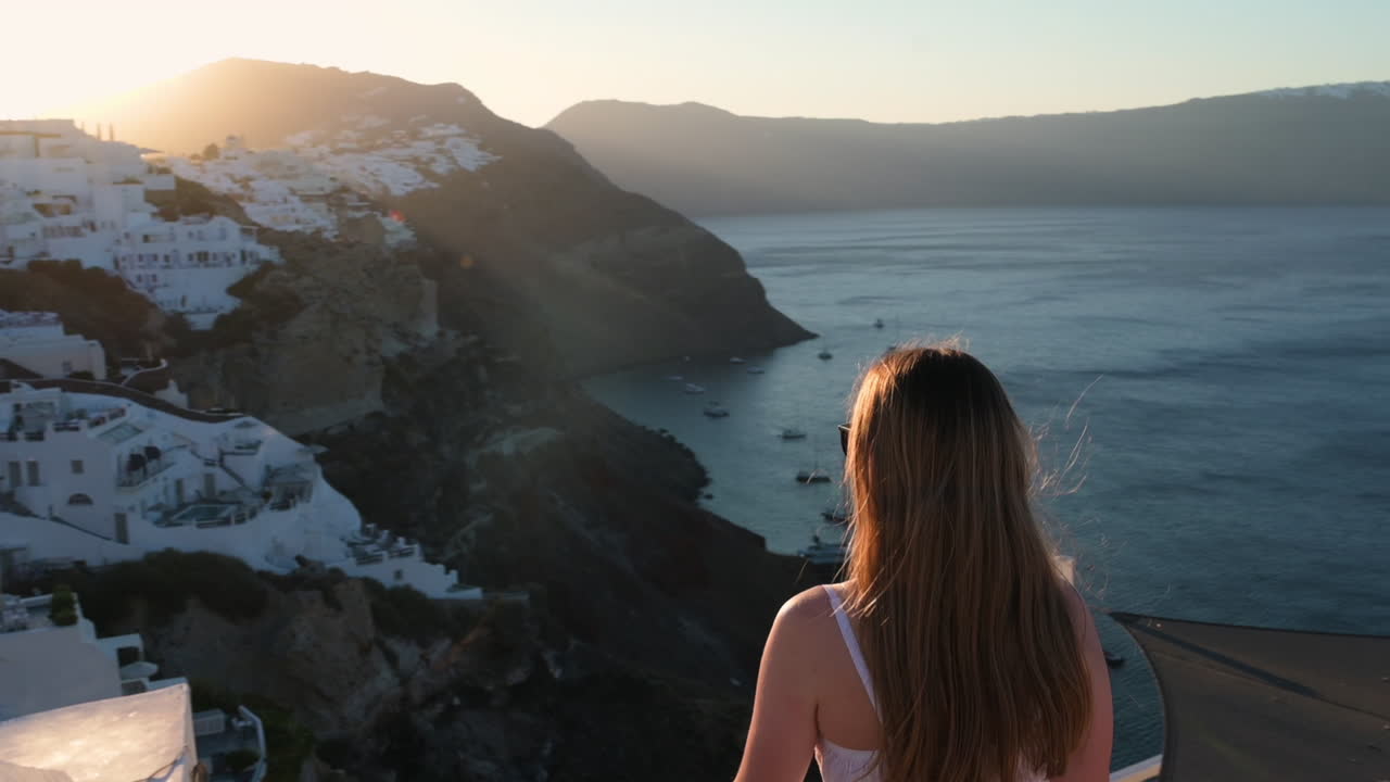 Woman enjoying sunset over Oia, Santorini