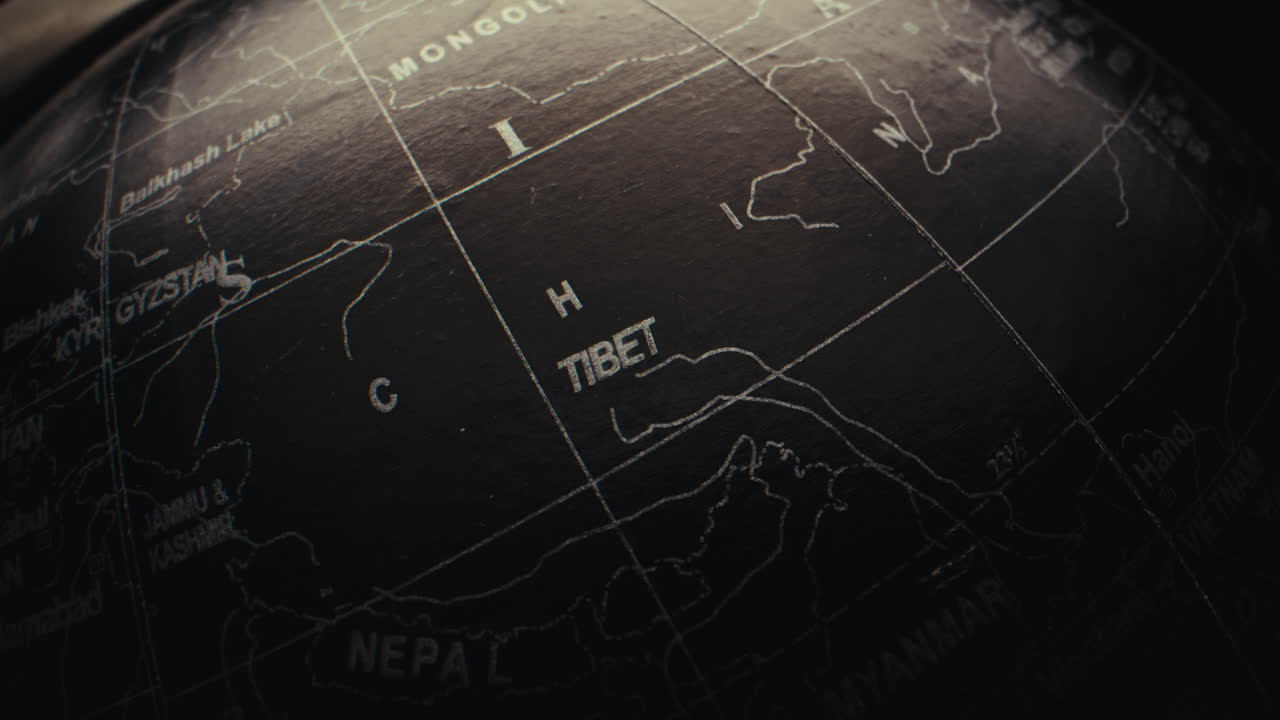 Close-up of a black and white globe, focusing on the Tibet region.