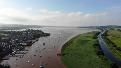 Szenische-Luftaufnahme-Von-Segelbooten,-Die-Im-Fluss-Exe-Neben-Grünen-Feldern-Und-Dem-Exeter-Kanal-Verankert-Sind