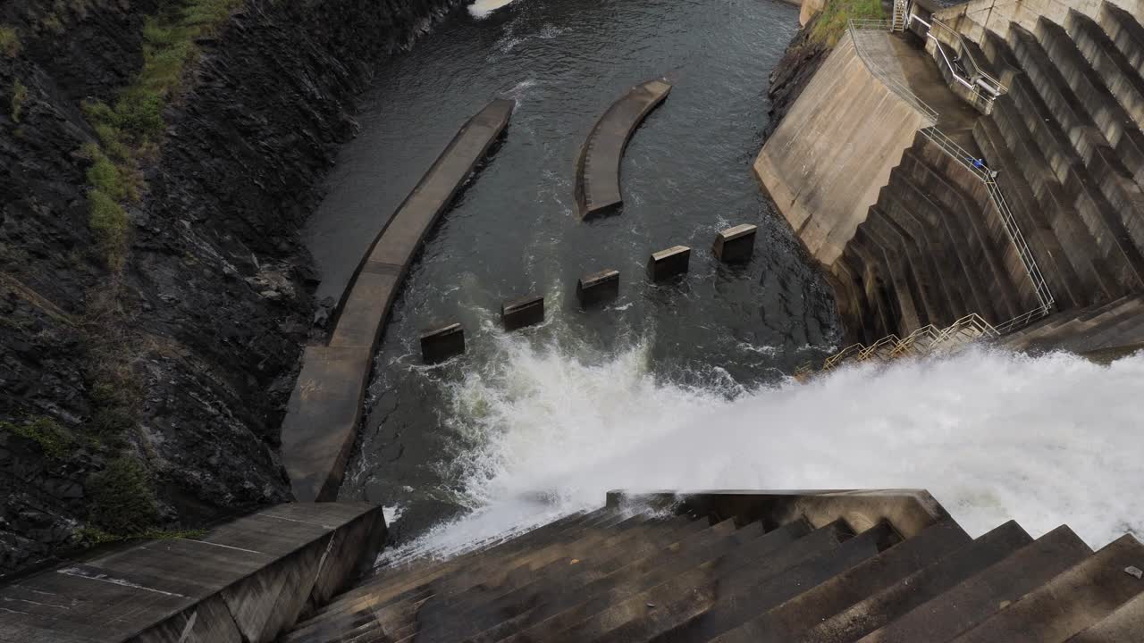 Top down wide side view of water flowing through the Hinze Dam overflow due to ongoing heavy rains in the Gold Coast Hinterland
