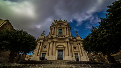 low angle shot of the baroque church of saint giovanni evangelista, in the historic center of in sicily, italy on a cloudy day in timelapse