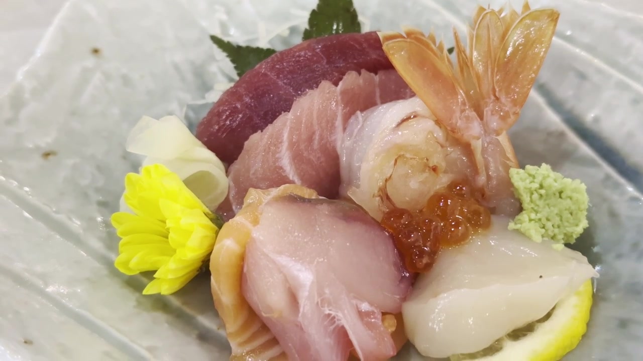 Primo piano di un piatto misto di sashimi con frutti di mare freschi di alta qualità, elegantemente disposto per un'autentica esperienza culinaria giapponese di alta classe