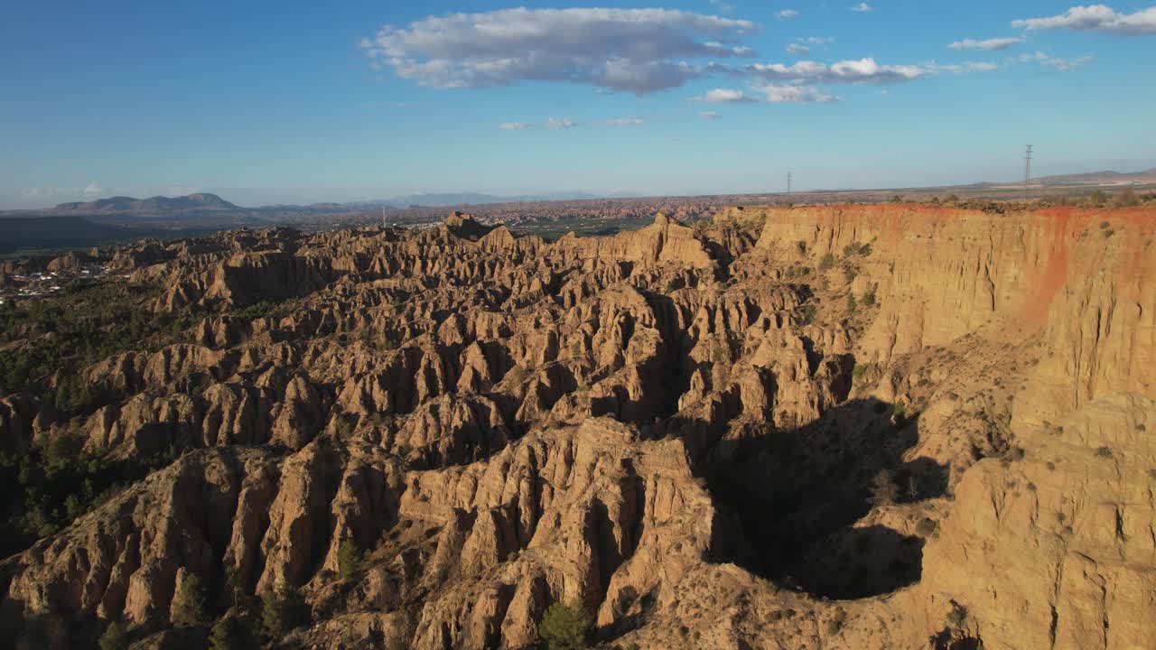 Desert mountains. Badlands. Aerial view. Low-altitude flight. Eroded mountains with strange shapes. Gullies, ravines, and gorges. Viewpoint of the End of the World. Purullena, Granada, Spain