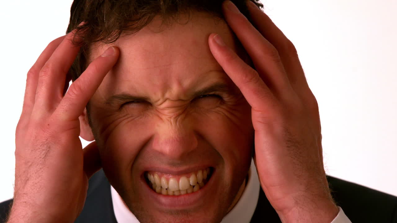 hombre de negocios enojado poniendo las manos sobre la cabeza