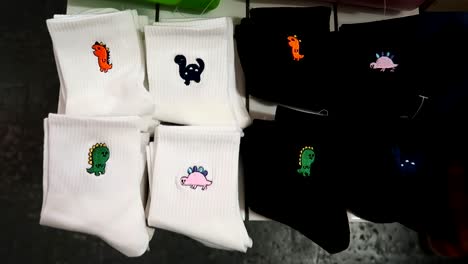 revealing shot of embroidered dinosaurs on socks on sale in a street market in london