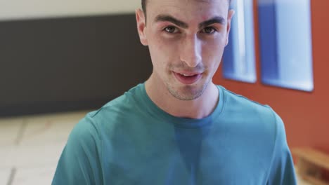 retrato de un jugador de baloncesto caucásico sosteniendo la pelota en una cancha cubierta, en cámara lenta
