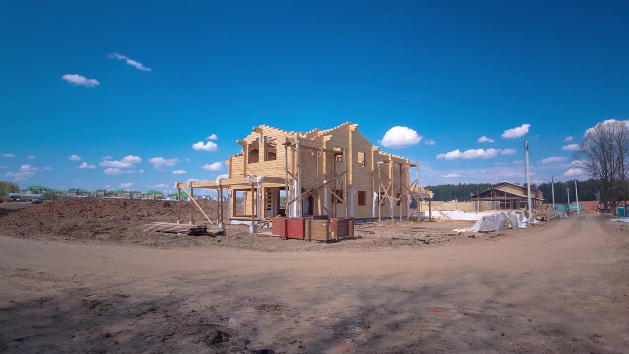Casa de madeira em construção, timelapse hyperlapse. Céu azul ao fundo.