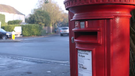 red post box by busy road junction with traffic