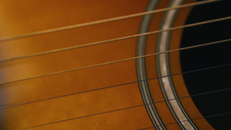 musician holds new acoustic guitar with brown body