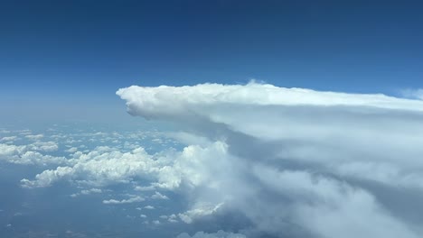 a pilot’s perspective of a huge storm cloud from above while flying at 12000m high