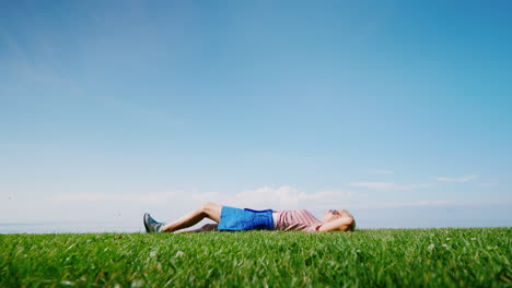 a happy woman lies in the middle of a green meadow relaxes and rests in nature alone