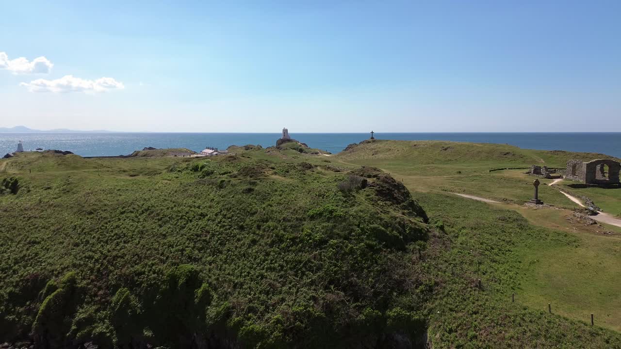 Ruins of St Dwynwens church on Ynys Llanddwyn walking trail aerial view descending to pebble beach
