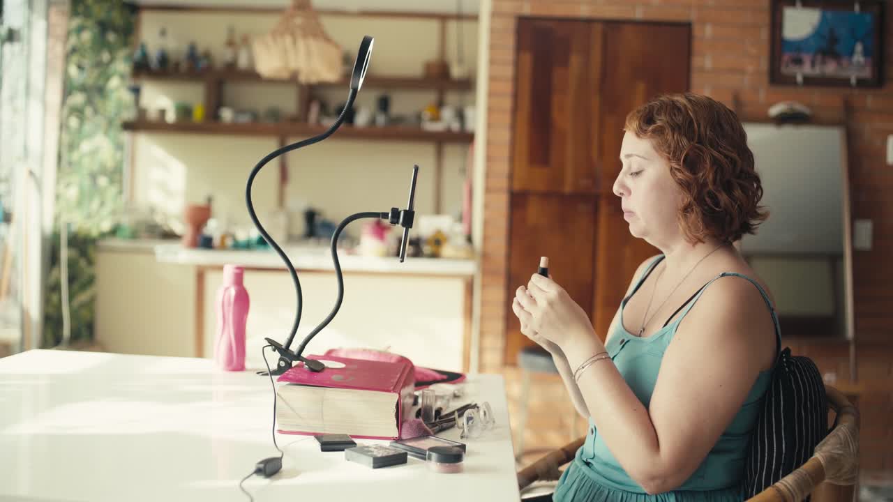 Una giovane donna registra una recensione di un prodotto make-up usando uno smartphone, Livestream