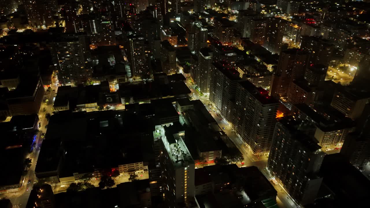 Vista aérea noturna de edifícios residenciais e do horizonte do centro da cidade em Santiago, Chile, no distrito de apartamentos urbanos.