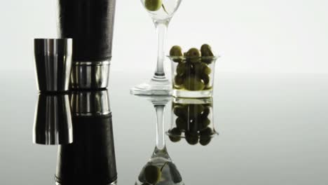 Glass-of-cocktail,-green-olives-and-cocktail-shaker