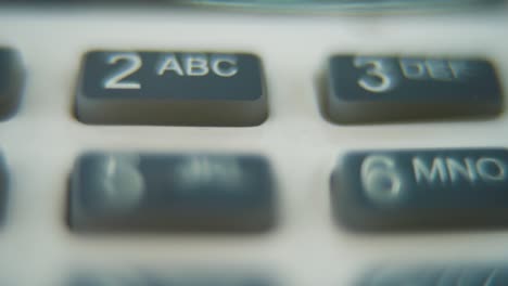 a macro close up shot of a pin pad numbers and letters on colorful buttons, zooming in movement, full hd video, super slow motion, blurry depth of field