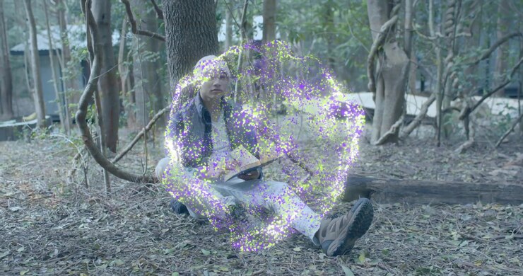 Man sitting tree opening paperback for education reading pausing to gaze canopy before closing book