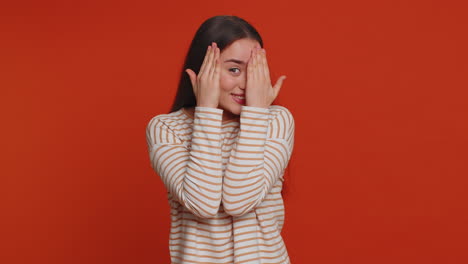 Nosy-curious-young-woman-closing-eyes-with-hand-and-spying-through-fingers,-hiding-and-peeping