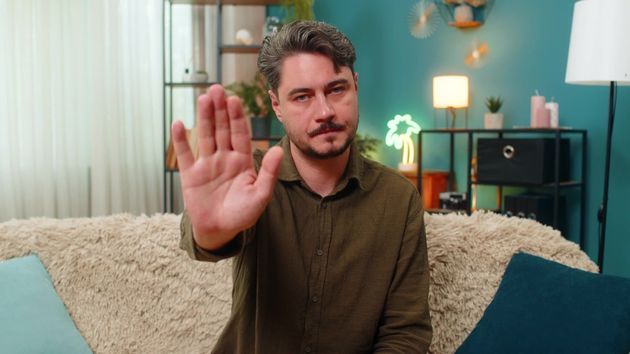 Middleaged man stop hand gesture staring serious signaling halt caution demanding negative response