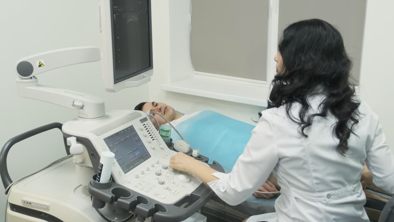 Woman doctor examines young man patient in ultrasound device, sonography.