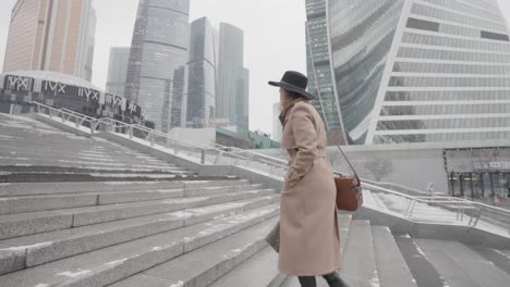 mujer subiendo escaleras en un paisaje urbano