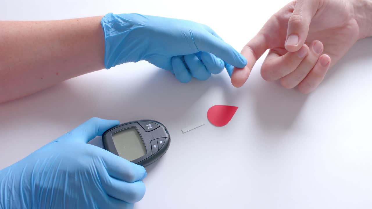 Hands of caucasian doctor and patient checking blood sugar level with glucometer, slow motion
