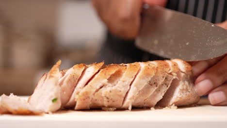 Hands-seen-slicing-cooked-chicken-breast-for-a-family-meal