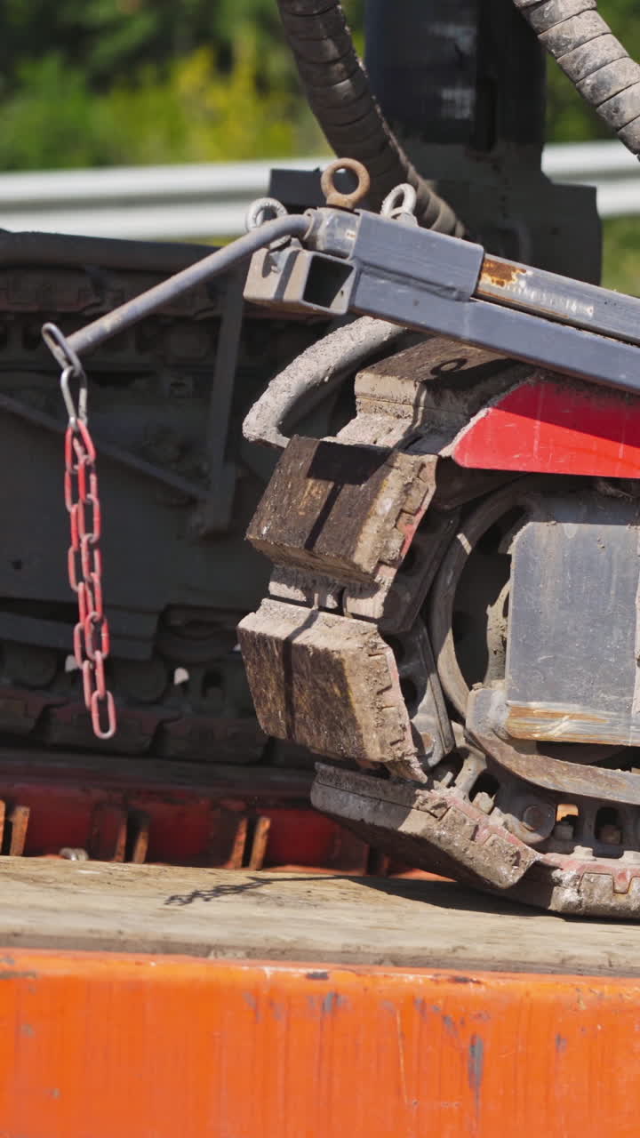 Caterpillar excavator in motion. Close-up of a caterpillar crawler machine that moves on metal support. Slow motion. Vertical video